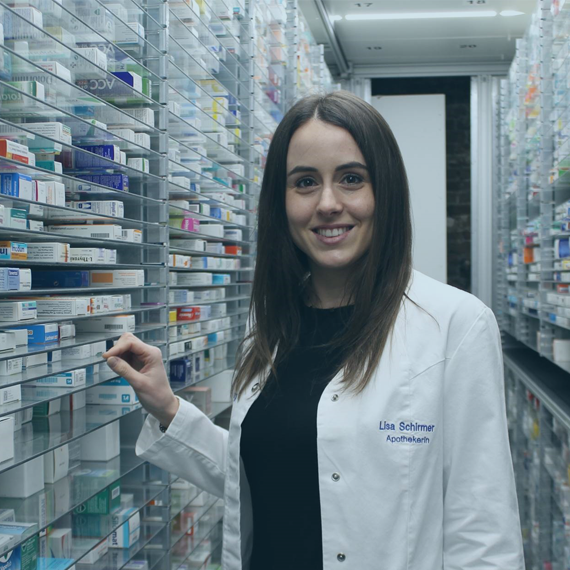 Apothekerin und Filialleitung - Lisa Schirmer steht zwischen den Medikamentenregalen in der Arnsburg Apotheke